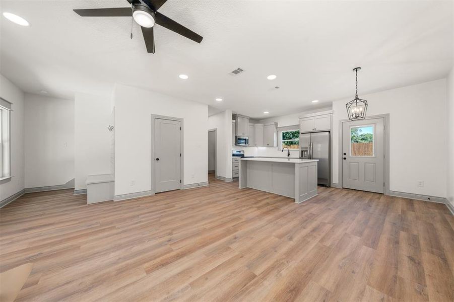 Kitchen featuring open floor plan, light countertops, a kitchen island, stainless steel appliances, and recessed lighting
