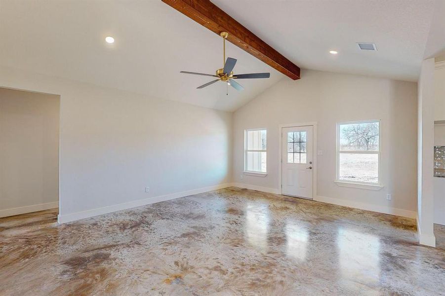 Unfurnished room featuring ceiling fan and lofted ceiling with beams