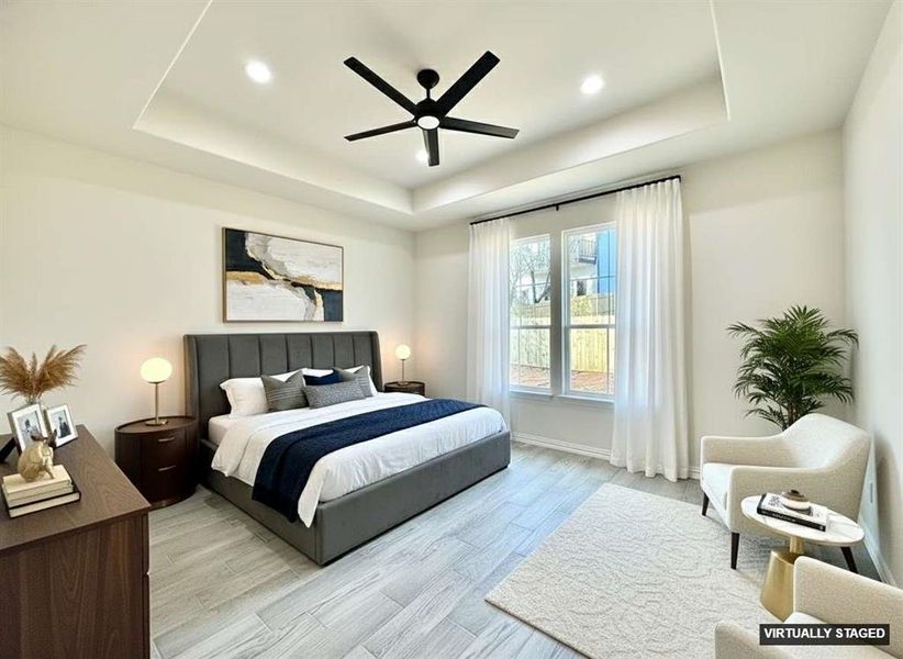 Bedroom with a tray ceiling, light wood-type flooring, a ceiling fan, and recessed lighting Bedroom with a tray ceiling, light wood-type flooring, a ceiling fan, and recessed lighting