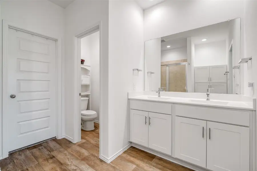 The primary bathroom features a sleek double sink vanity and a separate toilet room, offering a luxurious and functional space for relaxation and grooming. The primary bathroom features a sleek double sink vanity and a separate toilet room, offering a luxurious and functional space for relaxation and grooming.