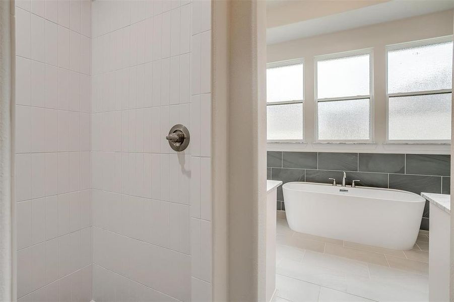 Bathroom with tile walls, tile patterned flooring, and a bathtub