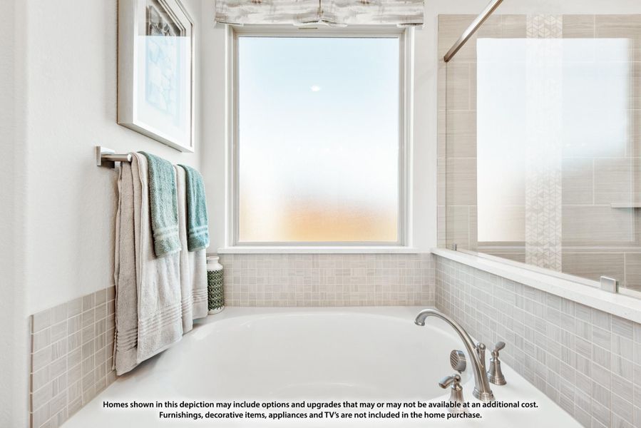 Bathroom with soaking tub, gray tile surround, large window, and separate glass shower enclosure Bathroom with soaking tub, gray tile surround, large window, and separate glass shower enclosure