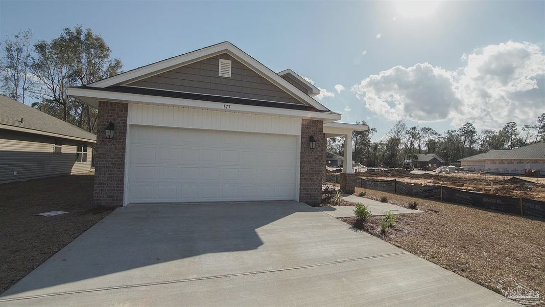 Front exterior of a new home in Pine Top, Cantonment, FL, highlighting curb appeal (Image 2).