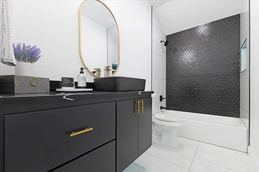 Bathroom featuring toilet, shower / bathing tub combination, tile patterned flooring, and vanity