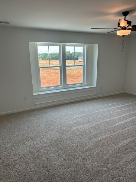 A plush carpeted room with abundant natural light A plush carpeted room with abundant natural light