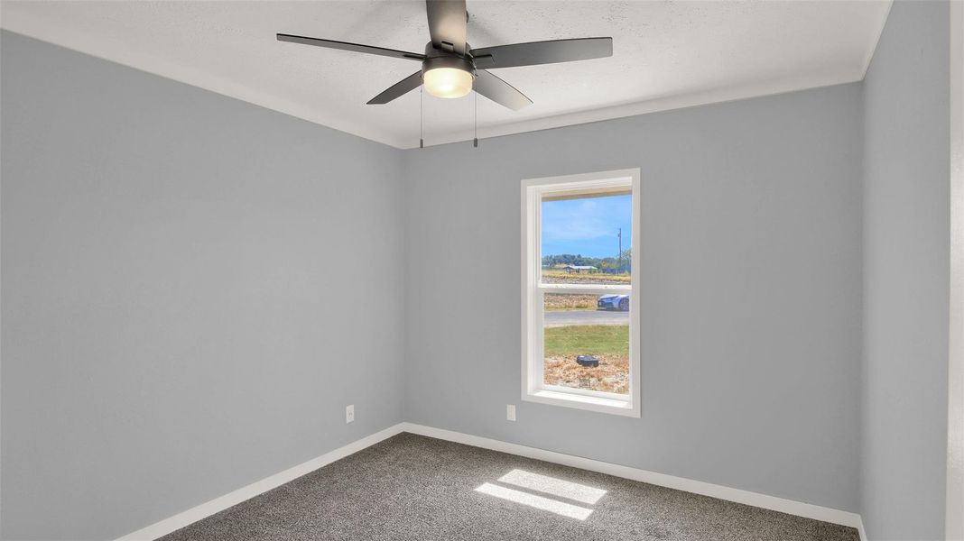 Clean lines and plush carpeting define this versatile secondary bedroom space.