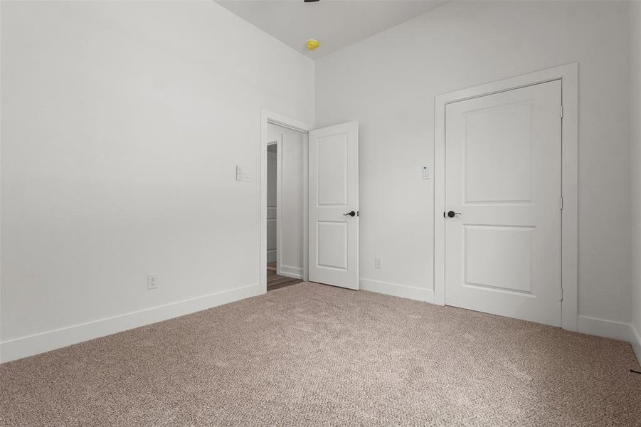 This room features light-colored carpeting and white walls, creating a bright and neutral aesthetic