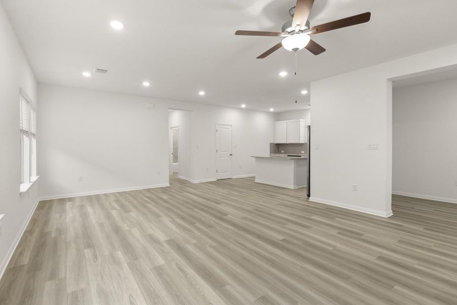 Open concept living space featuring light-toned flooring, recessed lighting, and a ceiling fan