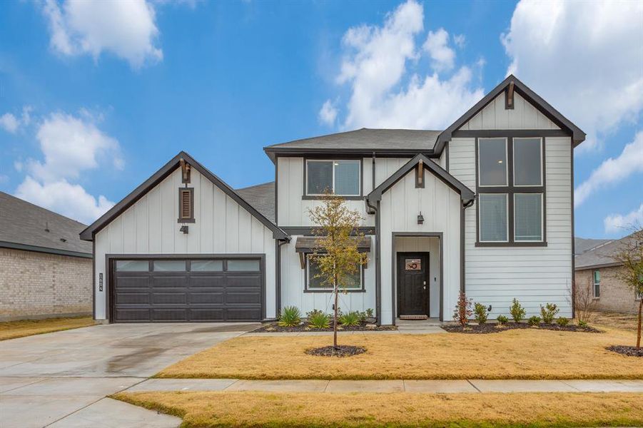 Modern farmhouse with a garage and a front lawn