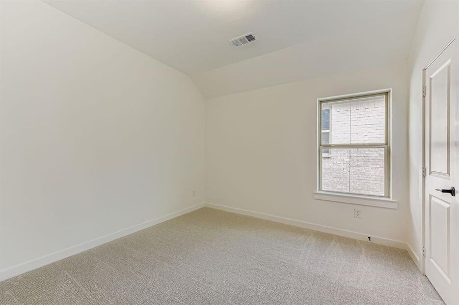 Spare room featuring lofted ceiling and light carpet Spare room featuring lofted ceiling and light carpet