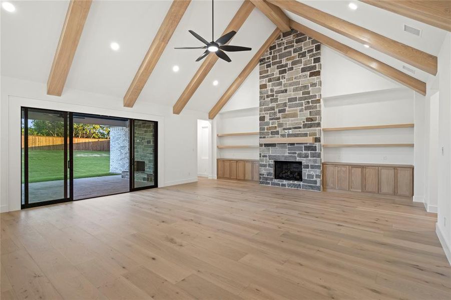 Unfurnished living room featuring a fireplace, recessed lighting, ceiling fan, light wood-type flooring, and lofted ceiling Unfurnished living room featuring a fireplace, recessed lighting, ceiling fan, light wood-type flooring, and lofted ceiling
