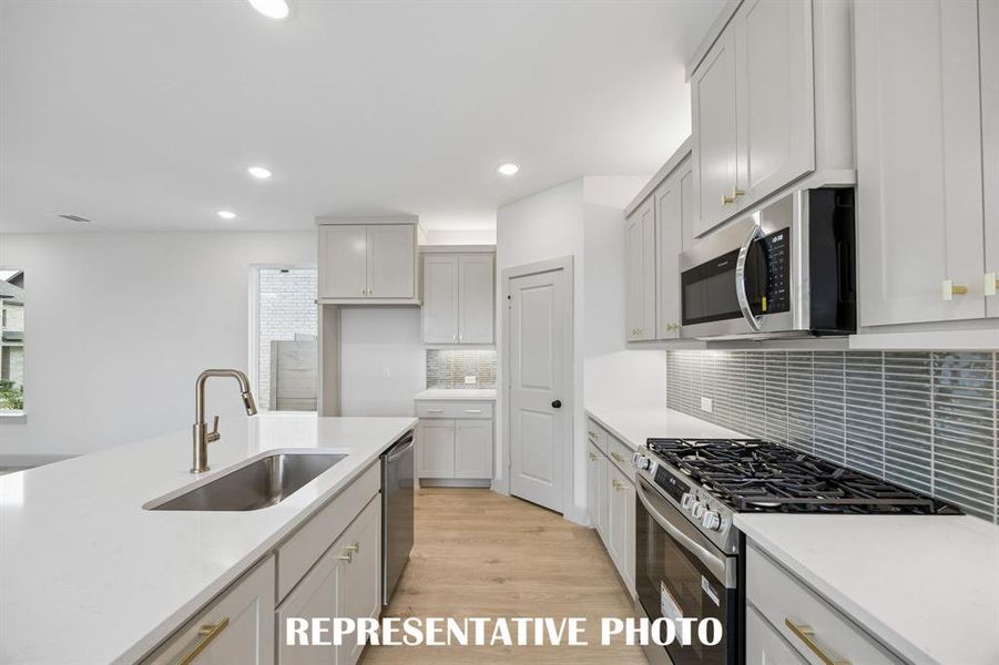 Beautiful cabinetry, gorgeous countertops and stylish backsplash effortlessly blend with contemporary stainless steel to create a kitchen for the ages!  REPRESENTATIVE PHOTO