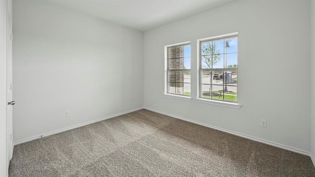 Carpeted empty room featuring baseboards