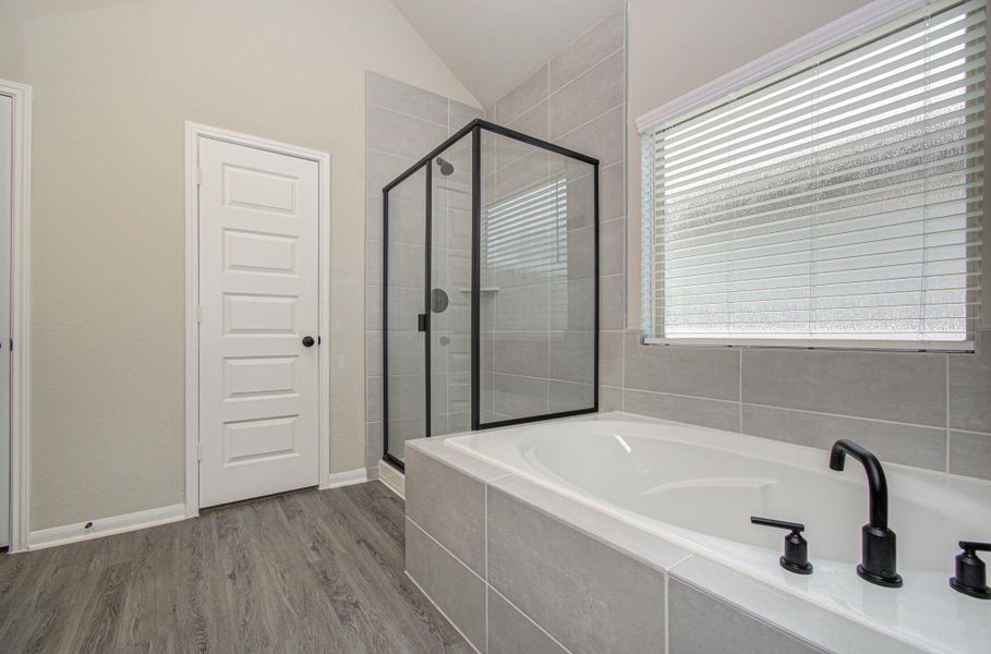 Upgraded primary bath includes separate garden soaking tub and separate shower
