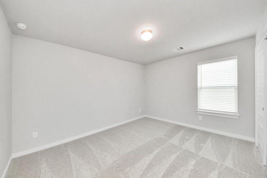 Secondary bedroom features plush carpeting, large windows that let in plenty of natural light, bright paint, and spacious closets. Sample photo of completed home with similar floor plan. Actual colors and selections may vary. Secondary bedroom features plush carpeting, large windows that let in plenty of natural light, bright paint, and spacious closets. Sample photo of completed home with similar floor plan. Actual colors and selections may vary.