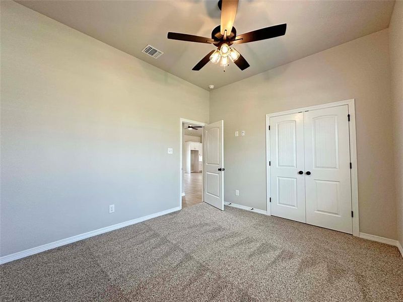Unfurnished bedroom with carpet floors, a ceiling fan, and a closet Unfurnished bedroom with carpet floors, a ceiling fan, and a closet