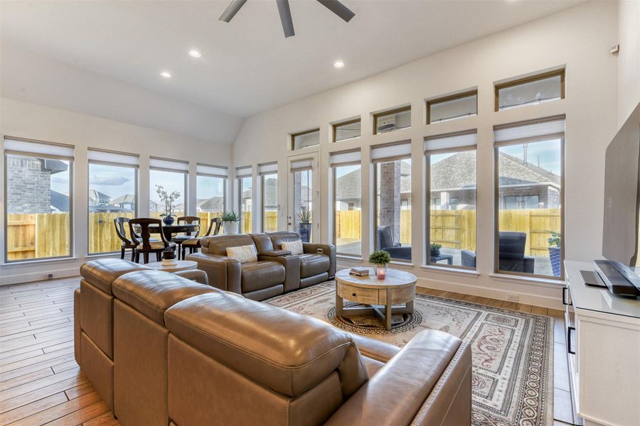Living room featuring a ceiling fan, light wood-type flooring, vaulted ceiling, and recessed lighting