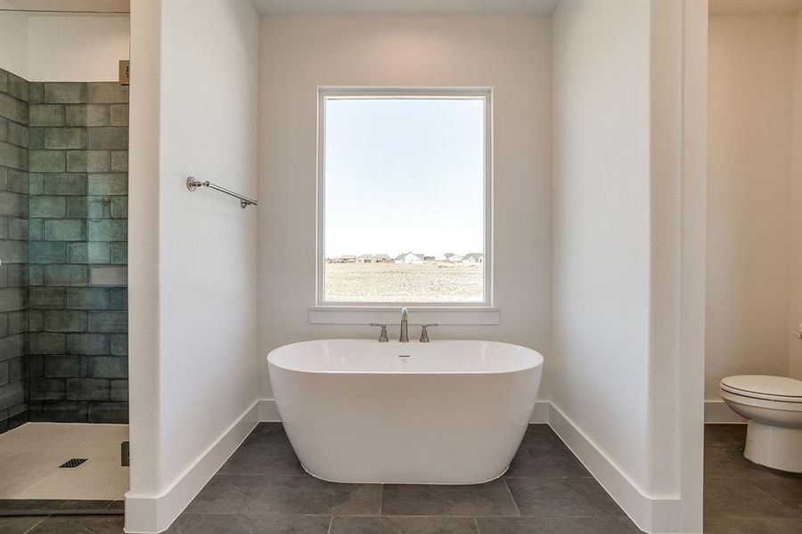 Full bath featuring a freestanding tub, a shower stall, and tile patterned flooring Full bath featuring a freestanding tub, a shower stall, and tile patterned flooring
