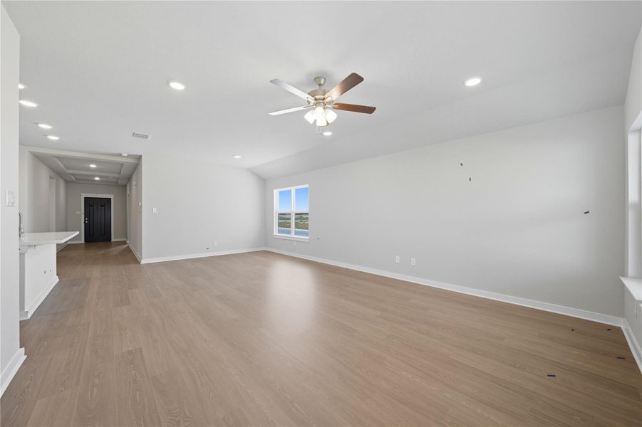 Unfurnished living room with recessed lighting, light wood-type flooring, ceiling fan, and vaulted ceiling Unfurnished living room with recessed lighting, light wood-type flooring, ceiling fan, and vaulted ceiling
