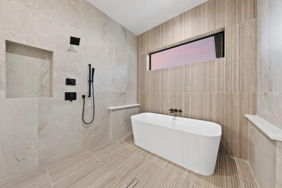 A well-appointed bath features a deep soaking tub and a sleek walk-in shower with modern fixtures.