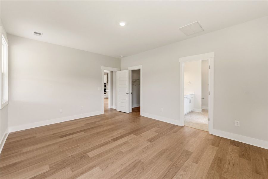 Hardwood floors stretch across this airy bedroom,
