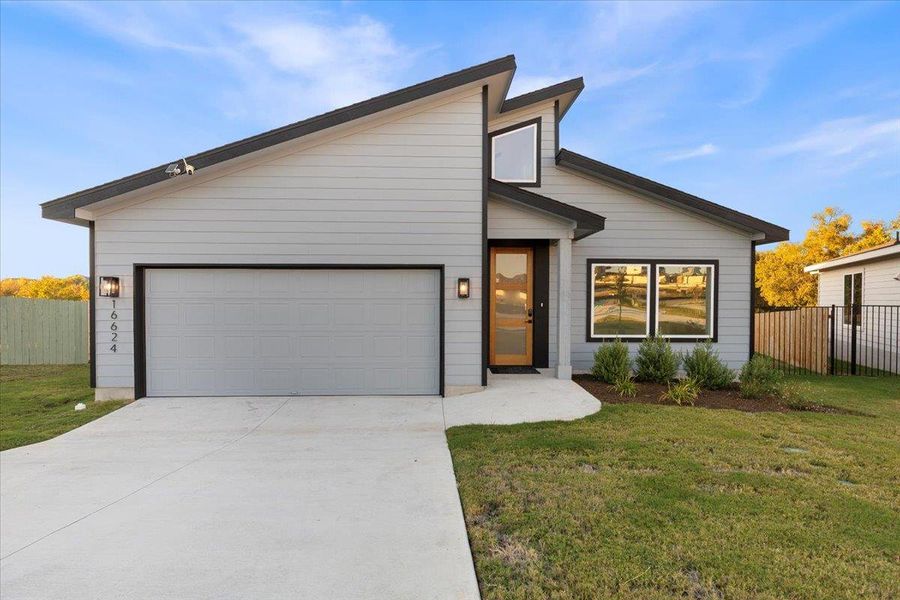 View of front facade featuring concrete driveway and an attached garage View of front facade featuring concrete driveway and an attached garage