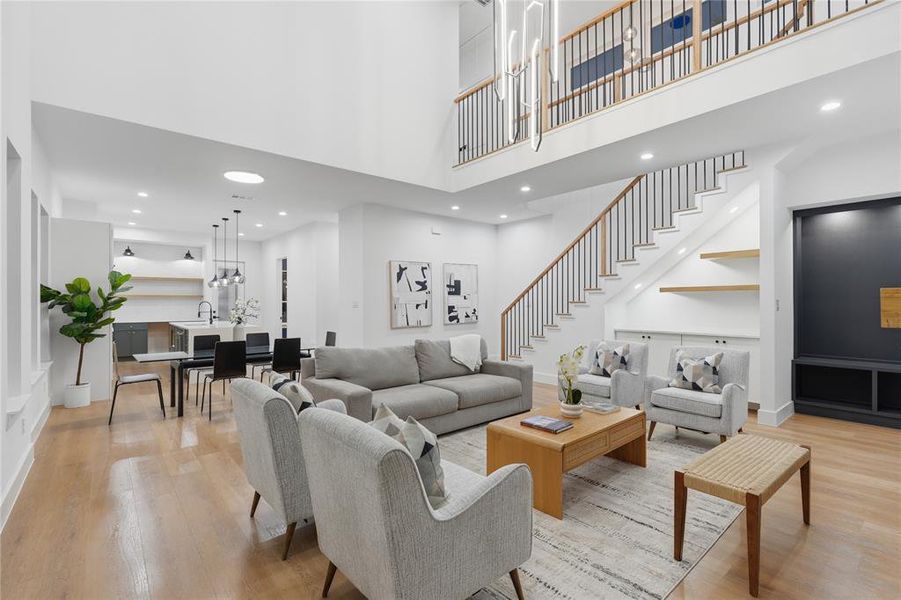 Two-story living area featuring a prominent staircase with wood handrails and black metal balusters Two-story living area featuring a prominent staircase with wood handrails and black metal balusters