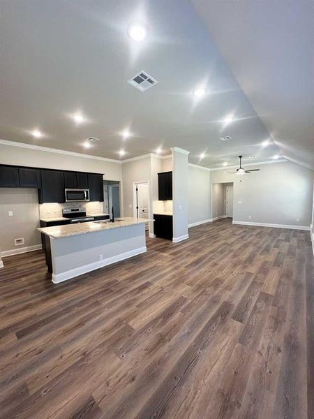 Kitchen featuring a kitchen island with sink, a sink, visible vents, dark cabinets, and appliances with stainless steel finishes