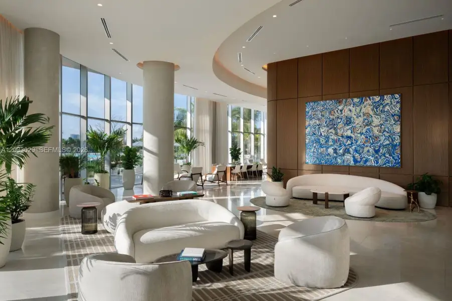 Floor-to-ceiling glass windows, recessed ceiling lighting, structural columns, and wood-paneled wall accent