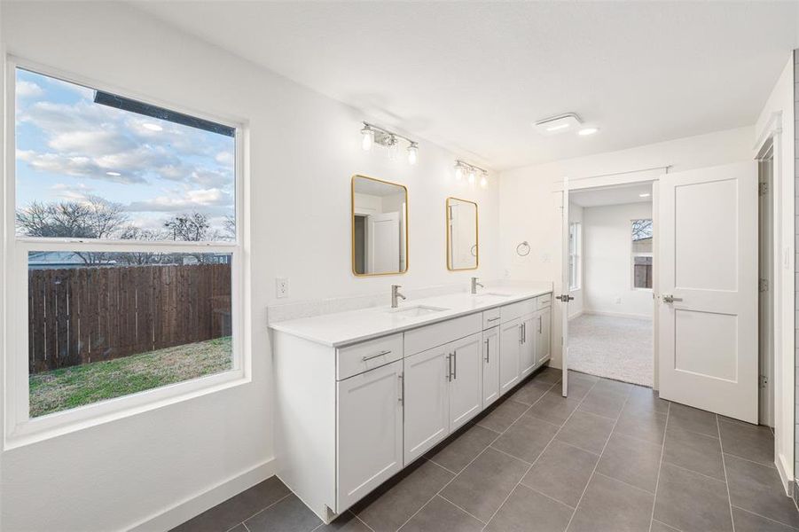 Full bathroom featuring tile patterned floors, a wealth of natural light, and a sink