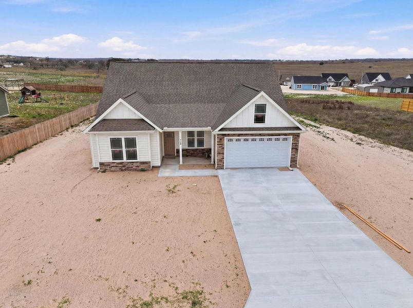 Front exterior of a new home in Las Palomas Country Club Estates, La Vernia, TX, highlighting curb appeal (Image 16).