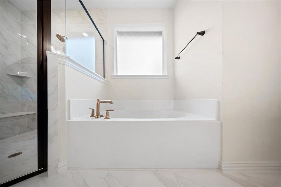 Bathroom with marble finish floors, a garden tub, and a marble finish shower