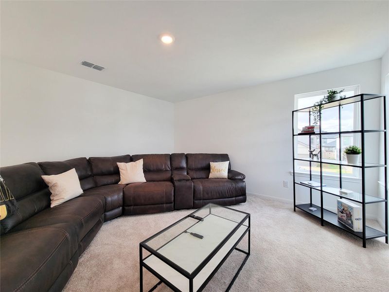 Spacious living room with neutral carpet and ample natural light from a window.