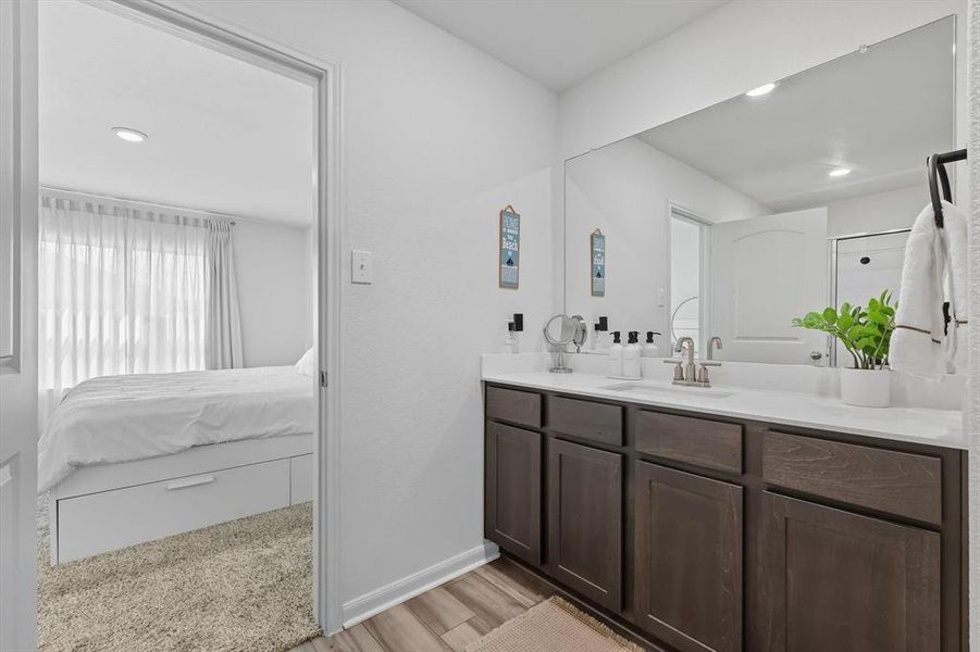 Ensuite bathroom featuring vanity, recessed lighting, and light wood-type flooring