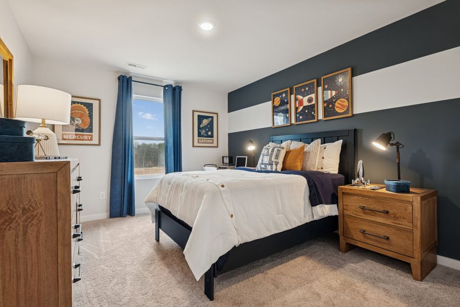 A bedroom with a bed and dresser.