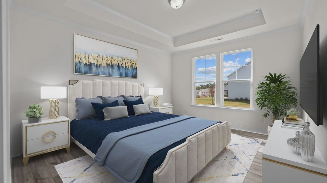 Fairfield spacious primary bedroom with raised tray ceiling and large windows. at Lakeside Glen by DRB Homes, York, SC.