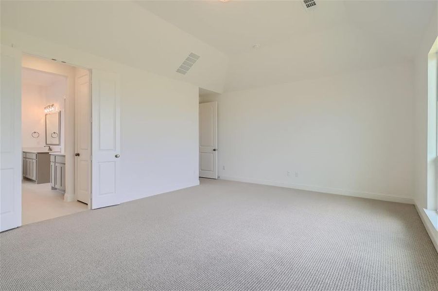 Unfurnished bedroom with light colored carpet and ensuite bath