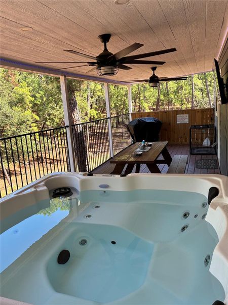 View of back deck / terrace with a hot tub, ceiling fan, area for grilling, and a wooden deck