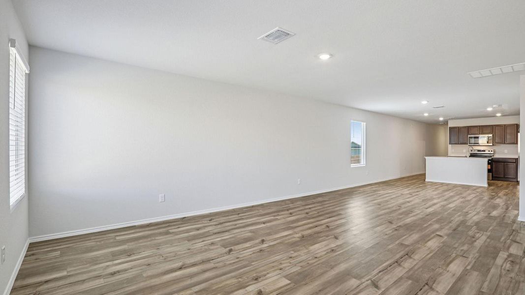 Unfurnished living room featuring recessed lighting and dark wood-style floors