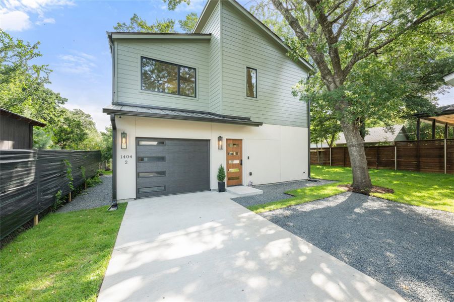 A striking modern facade features a sleek garage door and inviting wood entry. A striking modern facade features a sleek garage door and inviting wood entry.