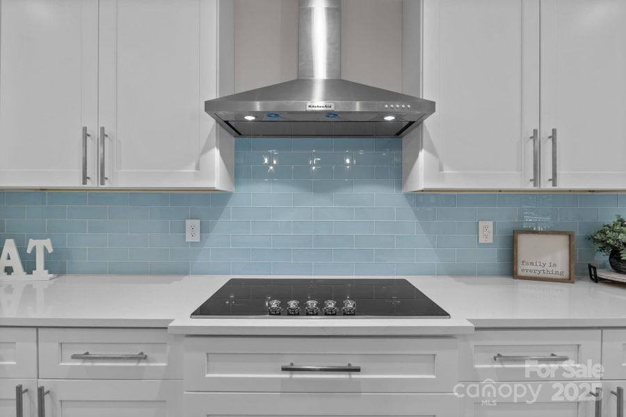 Gorgeous glass tile backsplash and vent hood