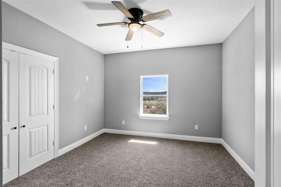 Unfurnished bedroom featuring carpet floors, a closet, and a ceiling fan