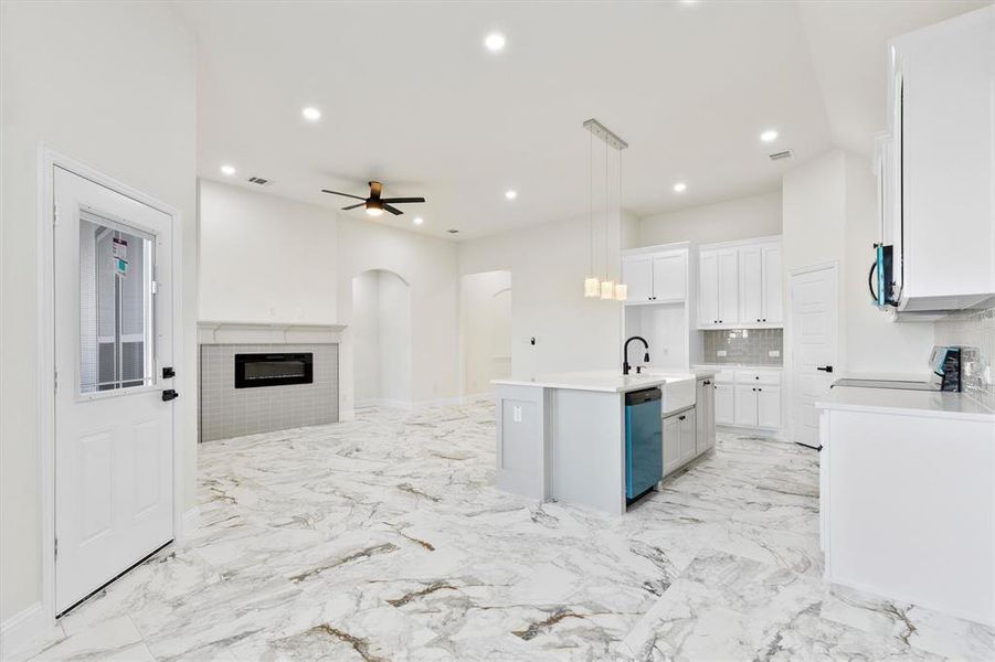 Kitchen featuring white cabinets, appliances with stainless steel finishes, open floor plan, marble finish floor, and recessed lighting Kitchen featuring white cabinets, appliances with stainless steel finishes, open floor plan, marble finish floor, and recessed lighting