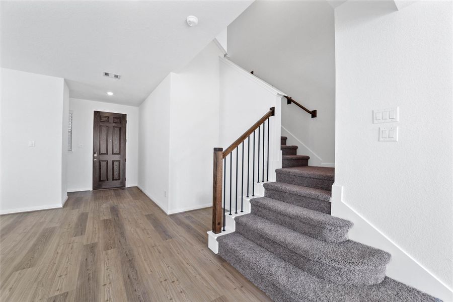 Step inside your new home, where the Bandera Light Pine vinyl plank flooring and fresh, bright paint create a warm and inviting entryway. Step inside your new home, where the Bandera Light Pine vinyl plank flooring and fresh, bright paint create a warm and inviting entryway.