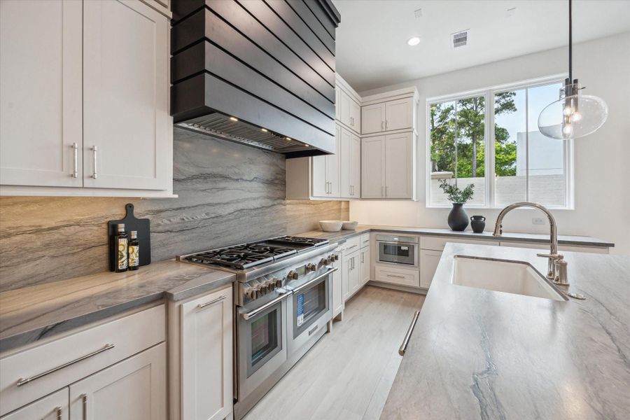 Leathered Blue Tahoe Quartzite waterfall island and undermount Porcelain sink with Kallista faucet complete this luxury kitchen. Ample prep space, storage space, and island seating make this space functional and stunning. Leathered Blue Tahoe Quartzite waterfall island and undermount Porcelain sink with Kallista faucet complete this luxury kitchen. Ample prep space, storage space, and island seating make this space functional and stunning.