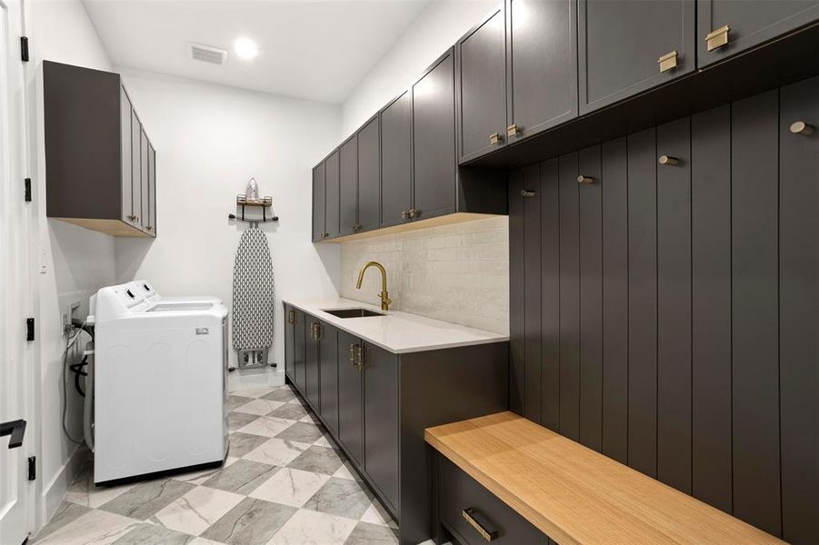 Laundry room featuring checkerboard-patterned flooring, dark cabinetry, and white countertops