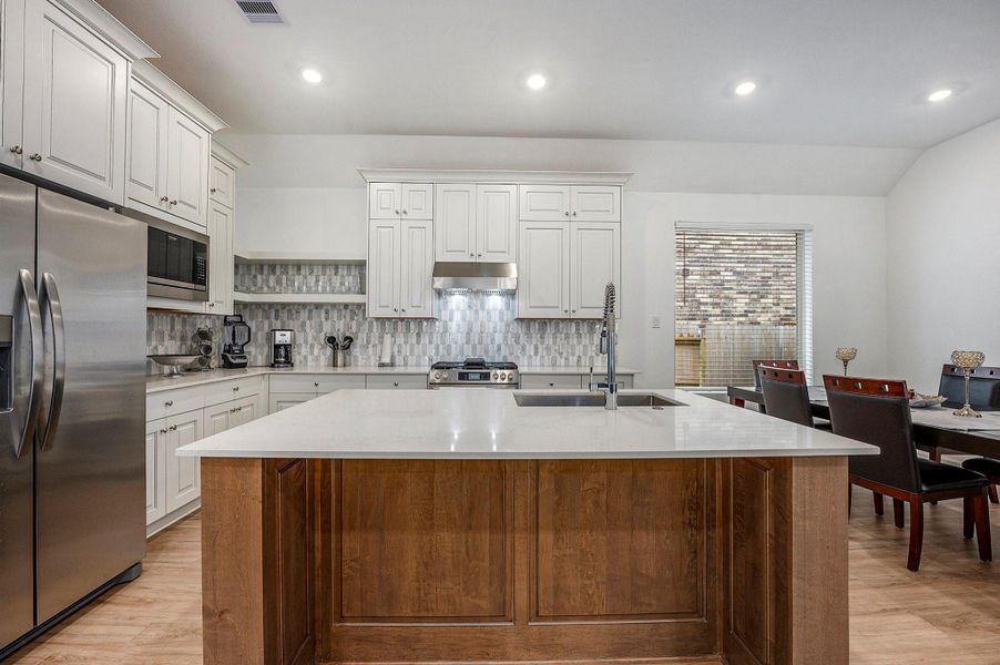 Chef-inspired kitchen with oversized island and farmhouse sink Chef-inspired kitchen with oversized island and farmhouse sink