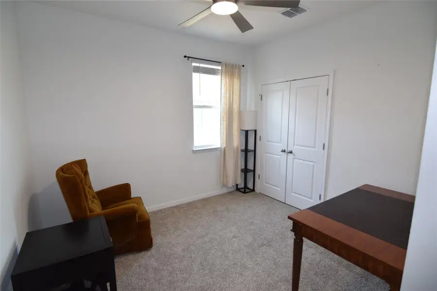 Carpeted floors and clean walls define this versatile room with double closet doors.