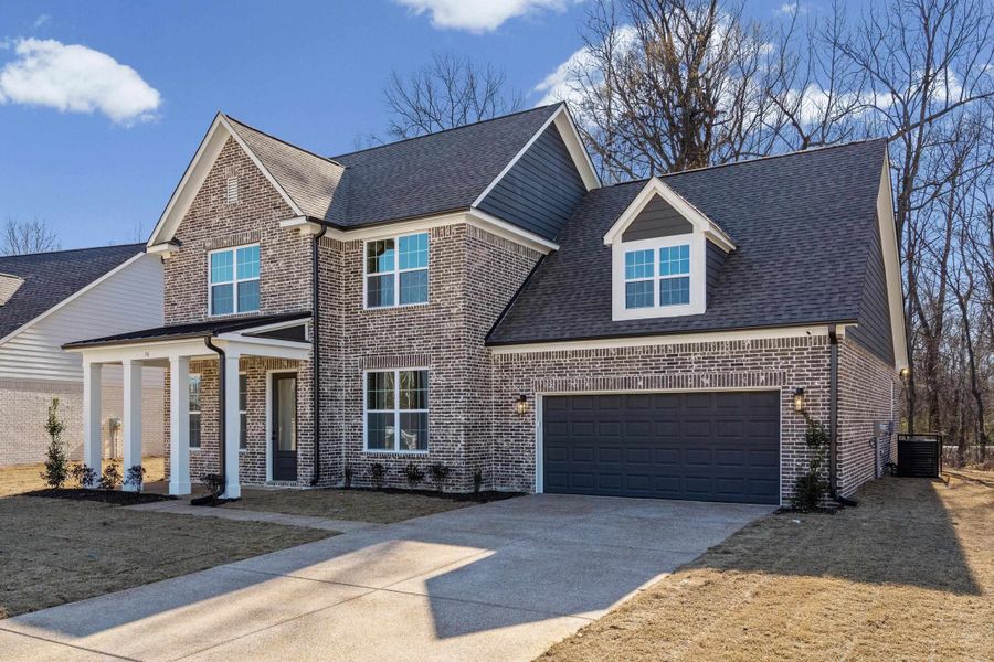 Traditional home featuring concrete driveway, roof with shingles, a garage, covered porch, and brick siding Traditional home featuring concrete driveway, roof with shingles, a garage, covered porch, and brick siding