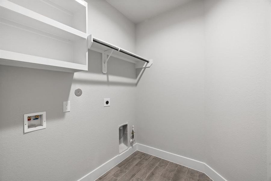 A perfect blend of functionality and comfort. Laundry room, thoughtfully equipped with shelving for effortless organization. Both gas and electric connections available. Sample photo of completed home with similar floor plan. Actual colors and selections may vary.